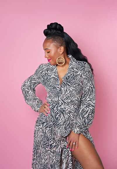 woman posing for the camera in front of a pink backdrop