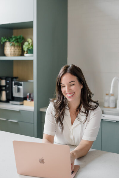 Branding session with a woman answering emails on her laptop.