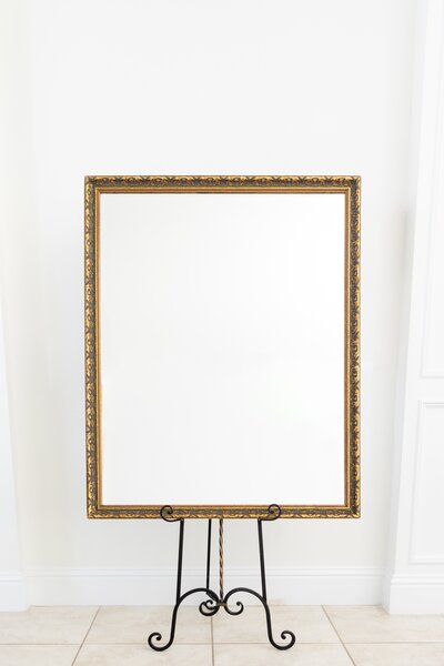 Gold rectangular mirror on black easel stand