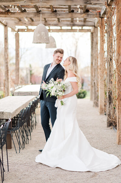 Sweet, romantic photo of a couple. He is carrying her in his arms while walking across Sleepy Ridge  Golf Course towards the Venue. Photo taken by Utah Wedding Photographers Andria Joleen Photography