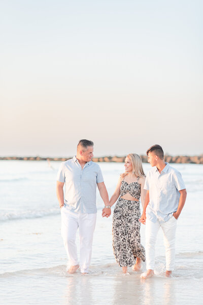 mom dad and teenage son walking on the beach family session by Miami lifestyle  photographers David and Meivys MSP Photography