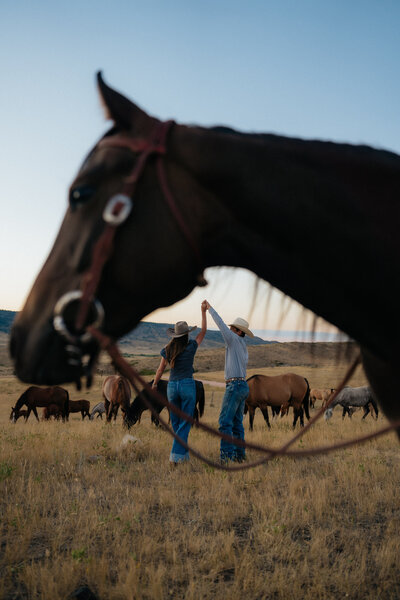 man twirling woman in a wyoming field among horses