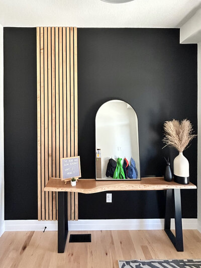 A black accent wall with vertical wooden slats