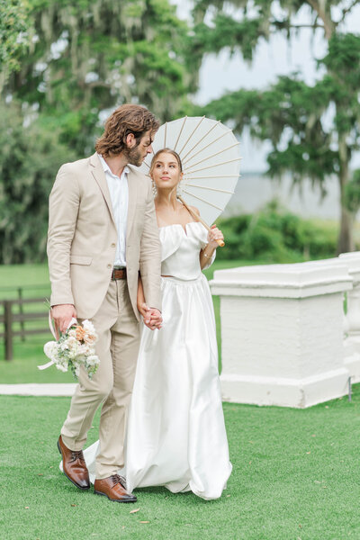 A couple that just got married at an altar surrounded by colorful flowers, the groom is behind the bride, and in the background its the Château Bouffémont