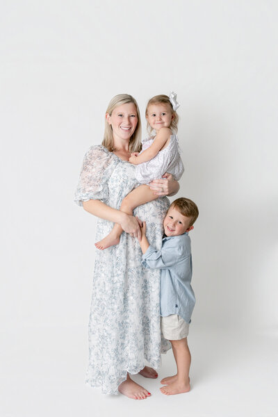 expectant parents with heads together embracing mom's belly at outdoor maternity session savannah.