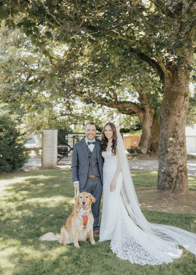 Bride and groom posing with their dog