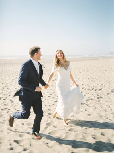 Couple running on beach at their Oregon Wedding
