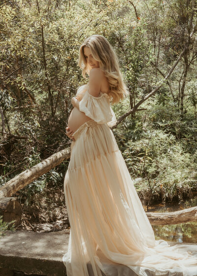 Beautiful mum-to-be posing for her Sydney photoshoot at sunset in an amazing brown gown.