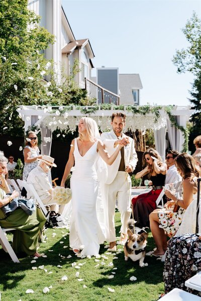 Bride and Groom Happy Grand Exit Down The Aisle with Flower Petals After Wedding Outdoors