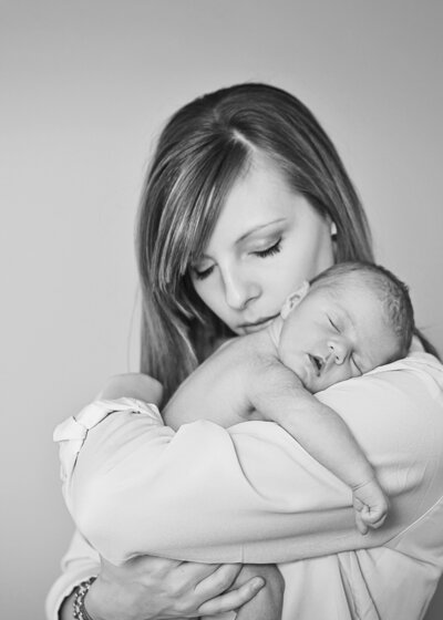 black and white image of mother and newborn baby both with eyes closed