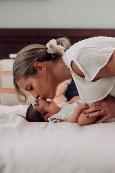 mom kissing baby on the forehead