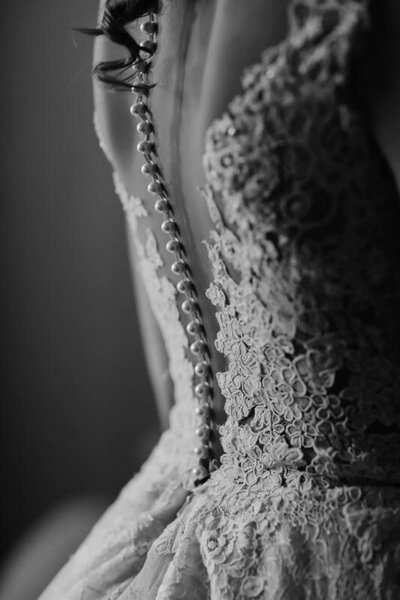 buttoning the brides wedding dress