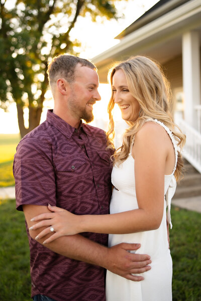 man and woman smiling and embracing while standing in a field