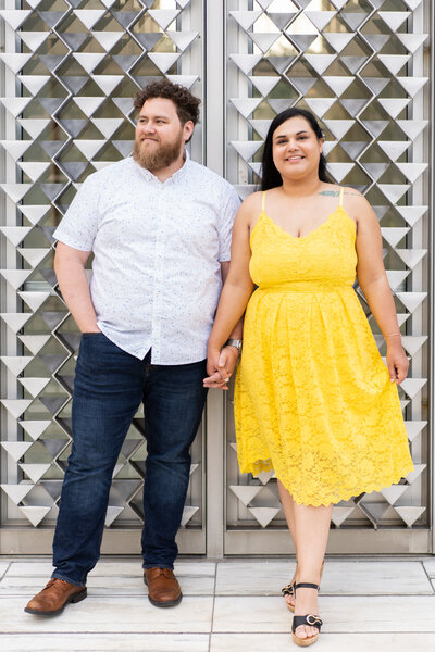 Couple standing on marble stairs with a textured door behind them