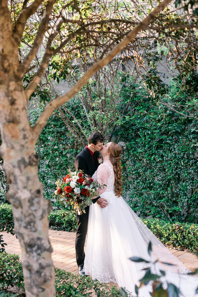 Bride and groom kissing in the garden at The White Church, Kalbar, captured by Brisbane wedding photographer Leanne J Photography