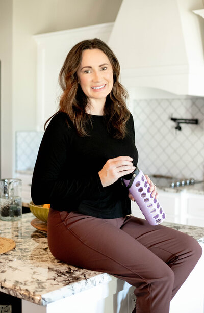 Trish, holistic nutritionist, yoga teacher, and breathwork coach, sitting with water
