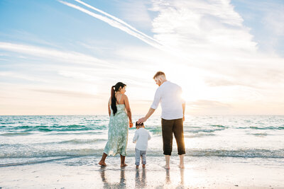 serene photo of a family of three on fort desoto beach in st pete fl.