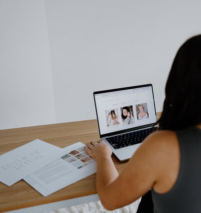 Danielle on computer with files on desk