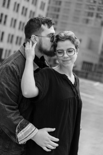 Engaged couple holding eachother during their outdoor engagement session in downtown Kentucky, captured by Abby Dutra Photography.