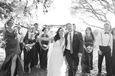An Austin-based wedding photographer captures a stunning black and white photo of a joyful wedding party.