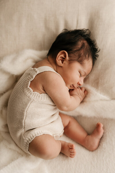 Photo of a newborn baby wearing a knitted romper