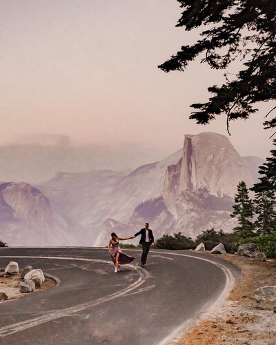 Bride and groom walking down road with mountains in the background
