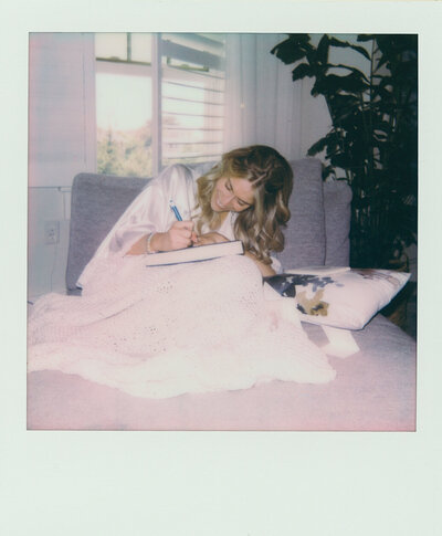 Close up of polaroids and shot film canisters with loose florals and fresh water pearls