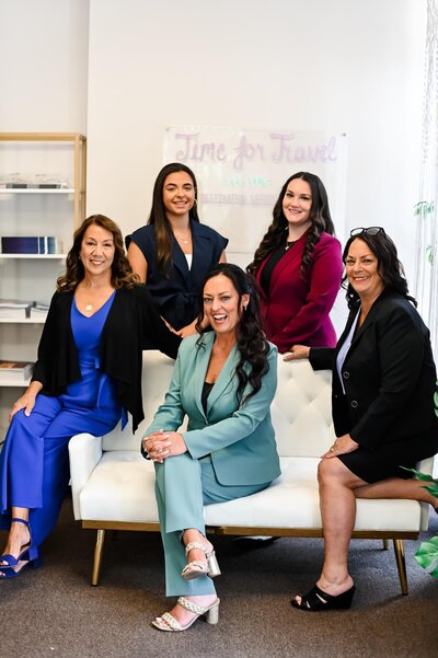 A team of expert destination wedding planners and travel agents posing in a professional office, specializing in Mexico weddings and honeymoon planning.