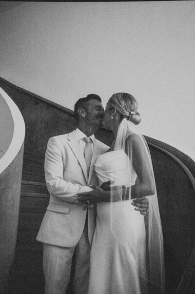 Bride and groom sharing a kiss on a staircase during a destination wedding weekend at Finest Playa Mujeres in Cancun, Mexico — multi-day celebration photography.