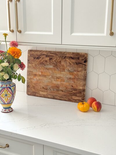 A wooden cutting board on a white countertop.