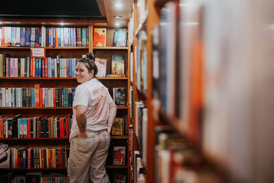 Jessie looks over her shoulder in a bookstore.