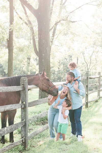 family and horse laughing on farm