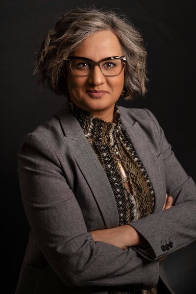 Female headshot posed with arms crossed