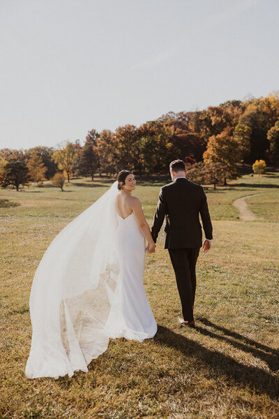Bride and Groom hold hands in outdoor fall wedding at National Arboretum