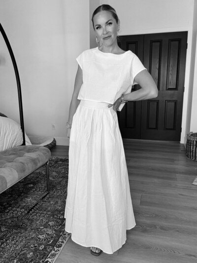 Women wearing tank top and jewelry hugging herself