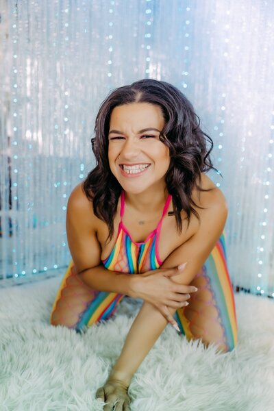 Women in rainbow lingerie smiles at the camera in Napa