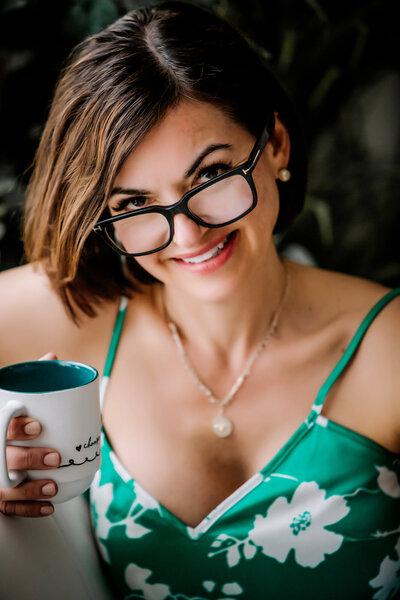 dating profile picture of a woman sitting on a couch, drinking coffee, and smiling while posing for a South Shore MA portrait photographer 