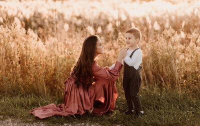 mother and son playing at sunset in a field in windsor for family photos