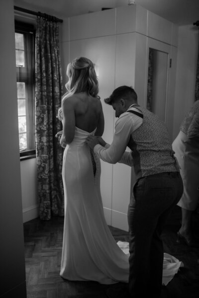 Bride getting zipped into dress