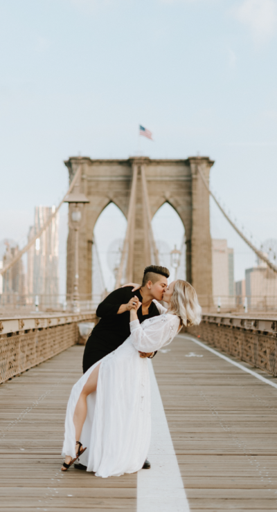 lgbt couple dancing on the brooklyn bridge in dumbo nyc