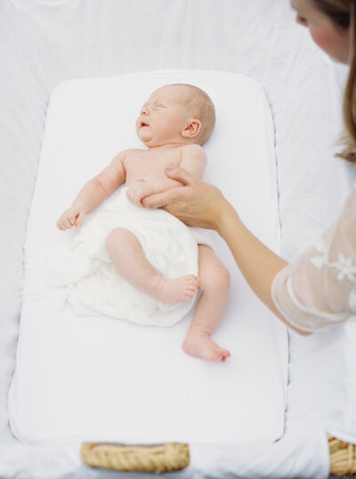 Newborn photography with baby lying in a white cot