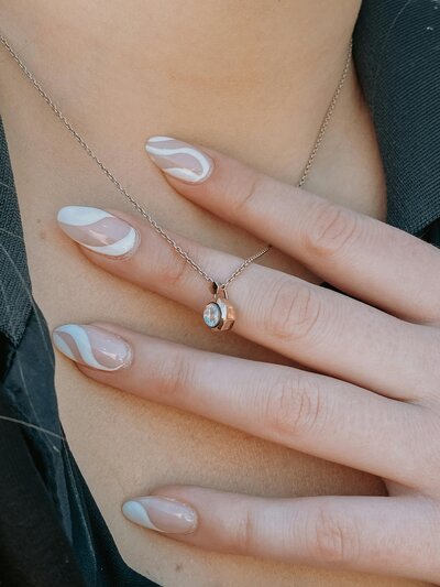 Close-up of nails featuring a soft nude manicure with delicate details.