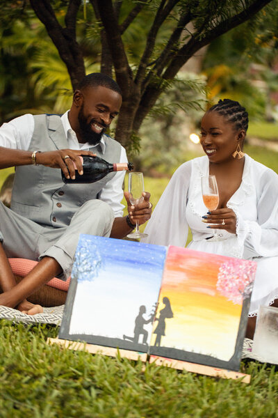 Engaged couple drink wine at picnic in The Bahamas