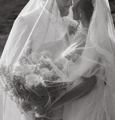 Intimate wedding portrait of a bride and groom sharing a quiet moment together in an outdoor setting