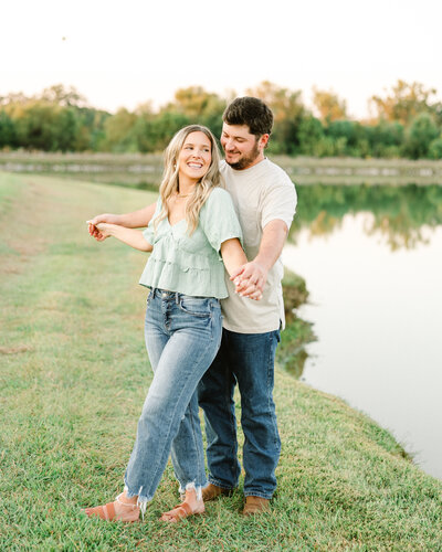 Kelby and Mason dancing by the lake, a stunning engagement moment captured by Abby Bell Photography. Romantic and timeless Alabama engagement photography.