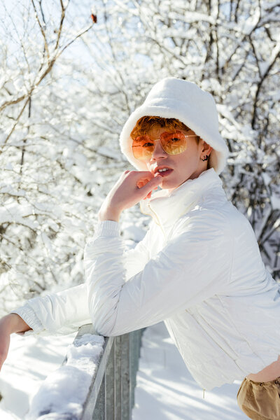 Robbie in white, posing for a solo fashion photography shoot during the winter season.