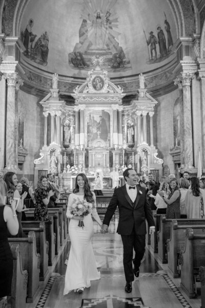 bride and groom exiting their ceremony in st john cantius catholic church