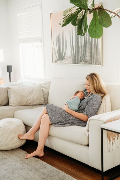 a new family of 3 cuddles in their baby's nursery