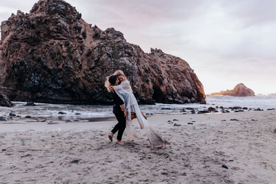 Destination Wedding Photographer captures groom lifting bride during beach bridals