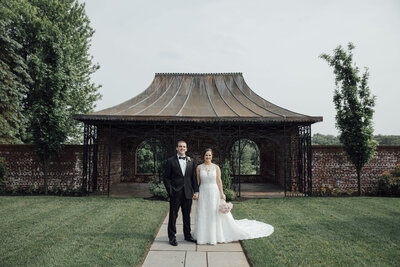 Hamilton Farms | Couple holding hands in front of tin-roof barn during wedding | Gladstone, New Jersey